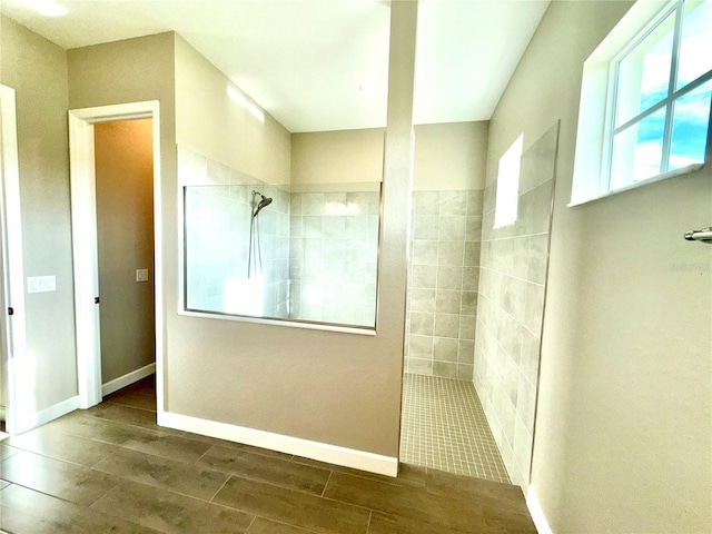 bathroom with wood tiled floor, baseboards, and a walk in shower