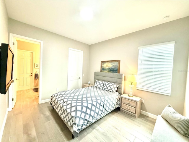 bedroom with wood finished floors and baseboards