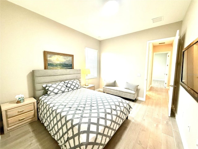 bedroom with baseboards and wood finished floors