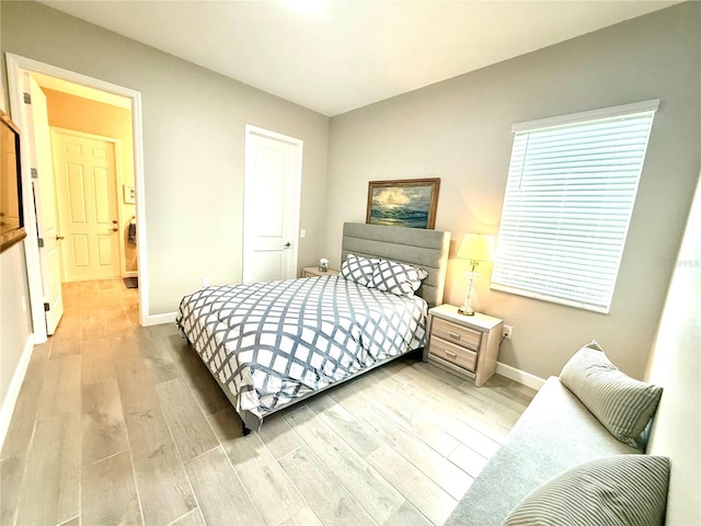 bedroom with wood finished floors and baseboards