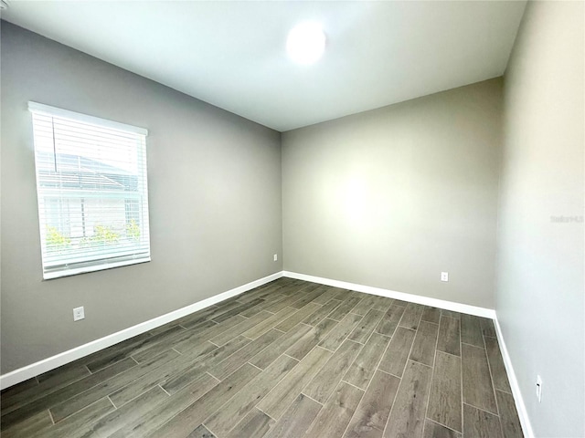 empty room featuring wood tiled floor and baseboards