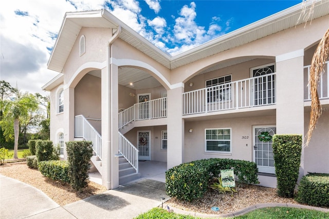 exterior space with stairway and stucco siding