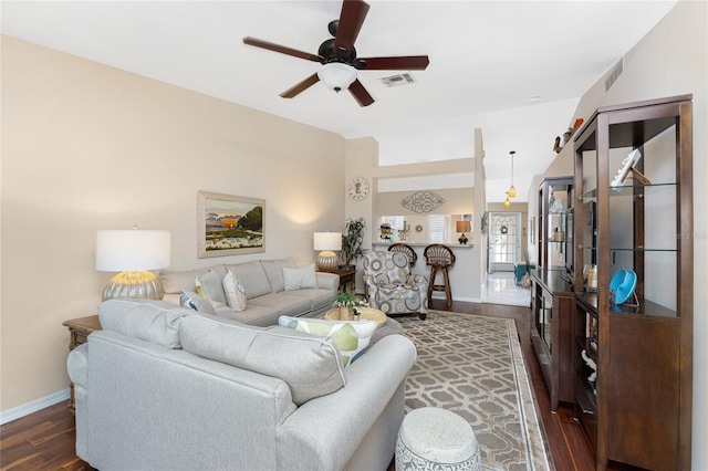 living room featuring baseboards, visible vents, ceiling fan, and dark wood-type flooring