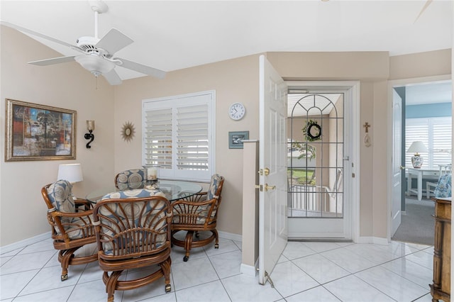 dining space featuring light tile patterned floors, baseboards, and a ceiling fan