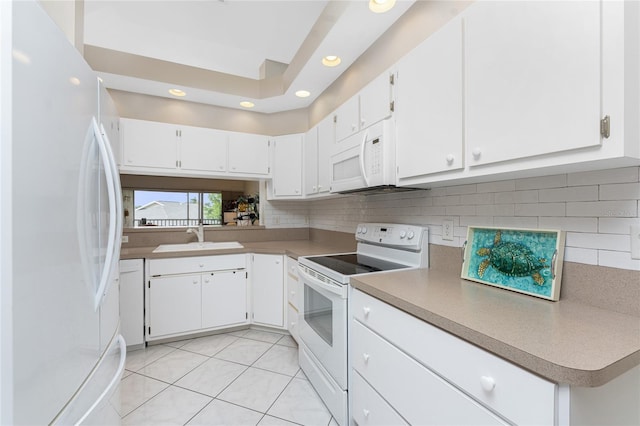 kitchen with white appliances, tasteful backsplash, light tile patterned floors, and a sink