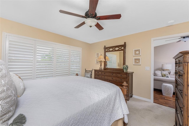 bedroom featuring ceiling fan, baseboards, and light colored carpet