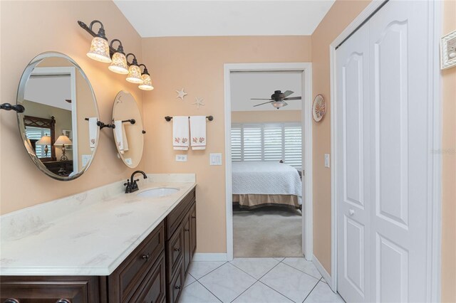 ensuite bathroom featuring tile patterned flooring, vanity, baseboards, and ensuite bathroom