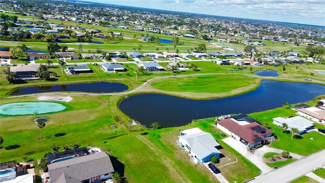 drone / aerial view with view of golf course, a water view, and a residential view