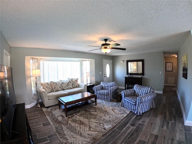 living area featuring ceiling fan, baseboards, and wood finish floors