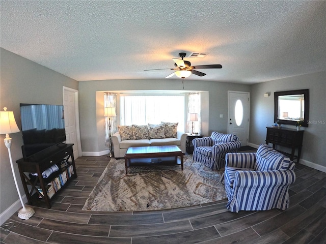 living area with wood finish floors, visible vents, ceiling fan, and baseboards