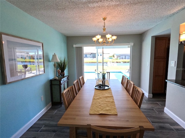 dining area with baseboards, wood finish floors, a textured ceiling, and a notable chandelier