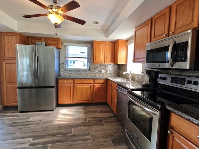 kitchen with appliances with stainless steel finishes, brown cabinets, and a sink