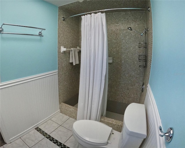 full bathroom with a stall shower, toilet, and tile patterned floors