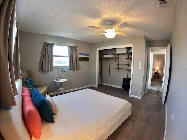 bedroom featuring baseboards, visible vents, ceiling fan, dark carpet, and a closet