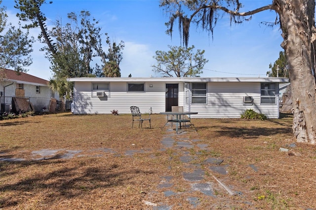 ranch-style home with a front lawn and fence