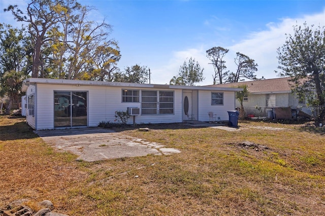 back of house featuring a patio area, a lawn, and a wall mounted air conditioner