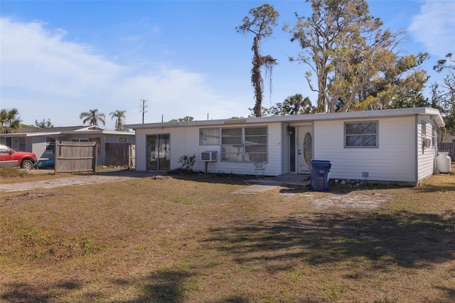 ranch-style home featuring a front lawn and fence