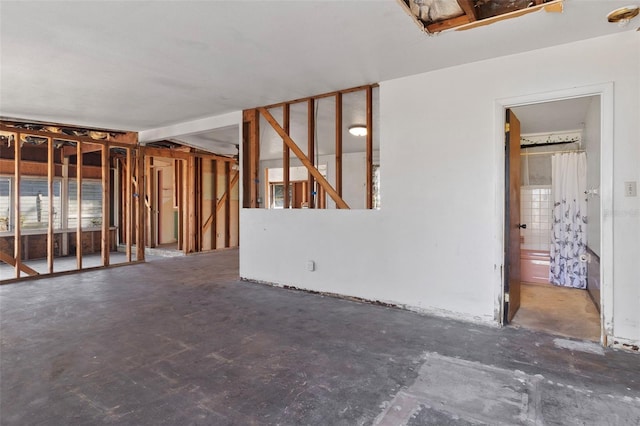 unfurnished living room with unfinished concrete flooring