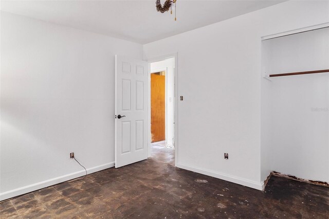 unfurnished bedroom featuring concrete flooring and baseboards