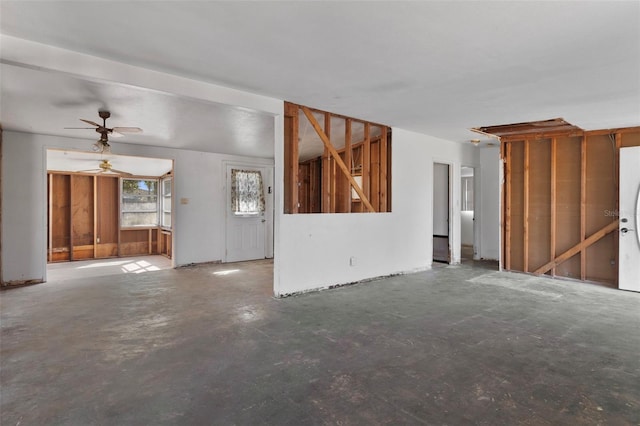 unfurnished living room featuring unfinished concrete flooring and a ceiling fan