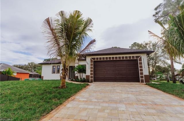 ranch-style home with a garage, decorative driveway, a front lawn, and stucco siding