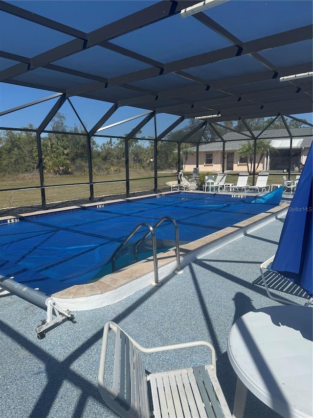 view of swimming pool featuring a lanai, a covered pool, and a patio