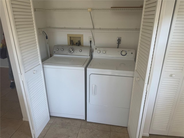 laundry room featuring light tile patterned floors, laundry area, and washing machine and dryer