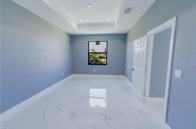 unfurnished room featuring recessed lighting, visible vents, baseboards, marble finish floor, and a raised ceiling