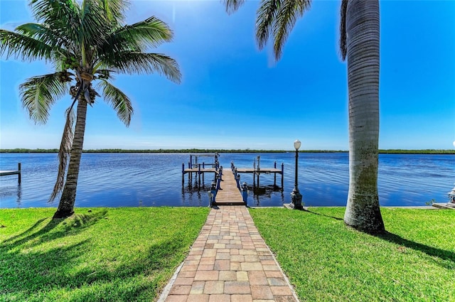 view of dock with a yard, a water view, and boat lift