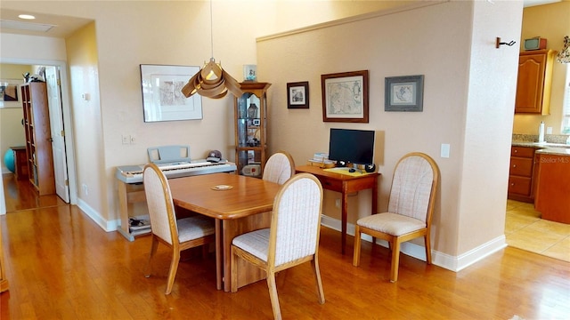 dining space featuring light wood-style floors and baseboards