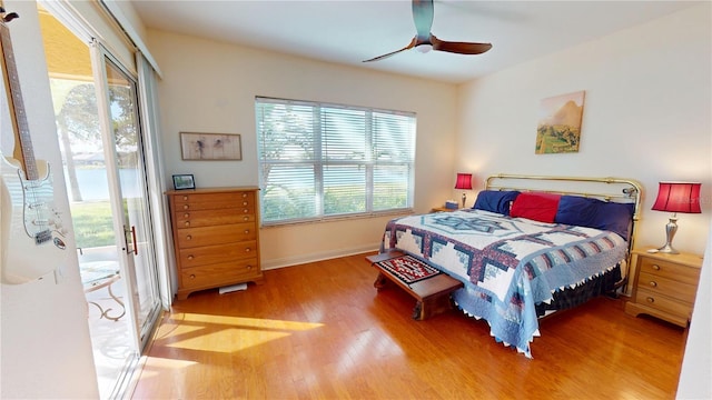 bedroom featuring ceiling fan, multiple windows, wood finished floors, and access to exterior