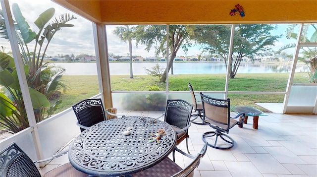 sunroom featuring a water view