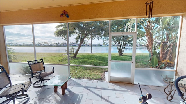 sunroom featuring a water view