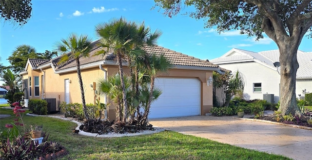 mediterranean / spanish house with a tiled roof, an attached garage, and stucco siding