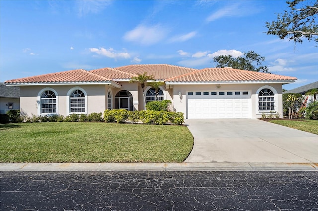 mediterranean / spanish-style house with stucco siding, an attached garage, a front yard, driveway, and a tiled roof