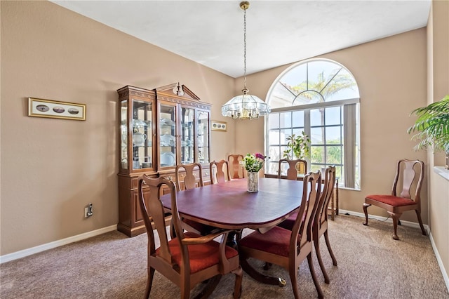 dining area with light carpet, baseboards, and an inviting chandelier