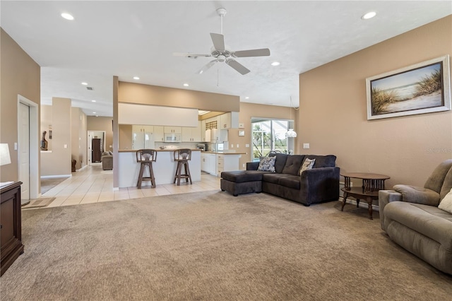 living room featuring light carpet, light tile patterned floors, a ceiling fan, and recessed lighting