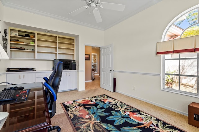 office space featuring ornamental molding, light carpet, baseboards, and a ceiling fan