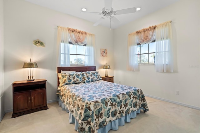 bedroom with recessed lighting, multiple windows, baseboards, and light colored carpet