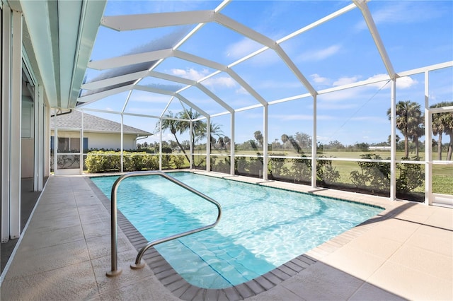 outdoor pool with glass enclosure and a patio area