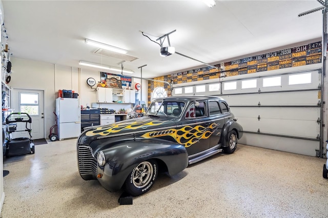 garage featuring freestanding refrigerator and a garage door opener