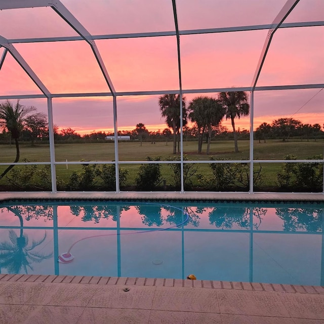 pool at dusk with a patio, a lanai, and an outdoor pool