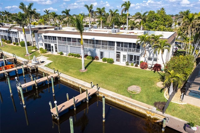 dock area featuring a water view, a yard, and boat lift