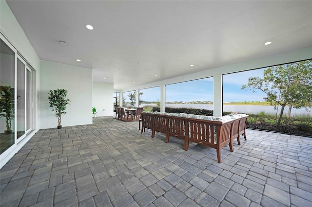 view of patio / terrace featuring outdoor dining space, a water view, and an outdoor living space