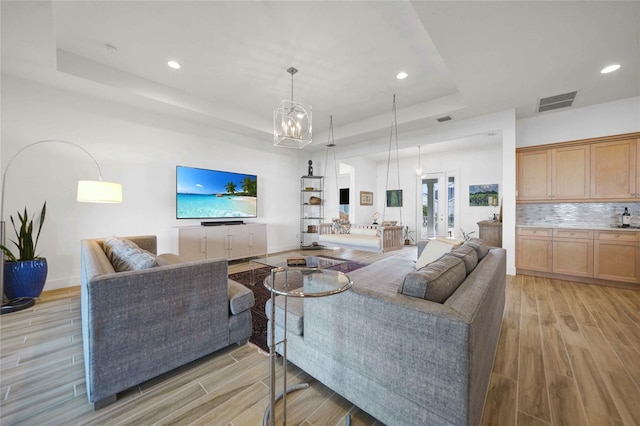 42239 Lake Timber Dr, Punta Gorda, FL 33982 - living area with a tray ceiling, light wood-type flooring, and visible vents