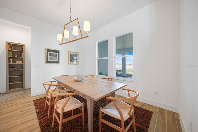 42239 Lake Timber Dr, Punta Gorda, FL 33982 - dining room with light wood-style flooring, baseboards, and a notable chandelier
