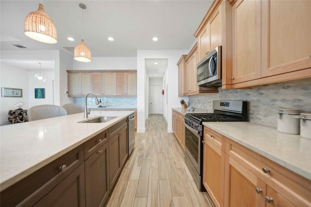 42239 Lake Timber Dr, Punta Gorda, FL 33982 - kitchen featuring visible vents, hanging light fixtures, stainless steel appliances, light wood-style floors, and a sink