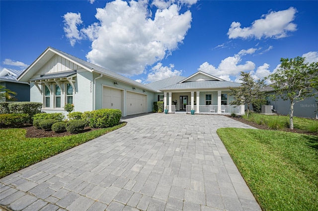 42239 Lake Timber Dr, Punta Gorda, FL 33982 - view of front of property with decorative driveway, covered porch, an attached garage, board and batten siding, and a front yard