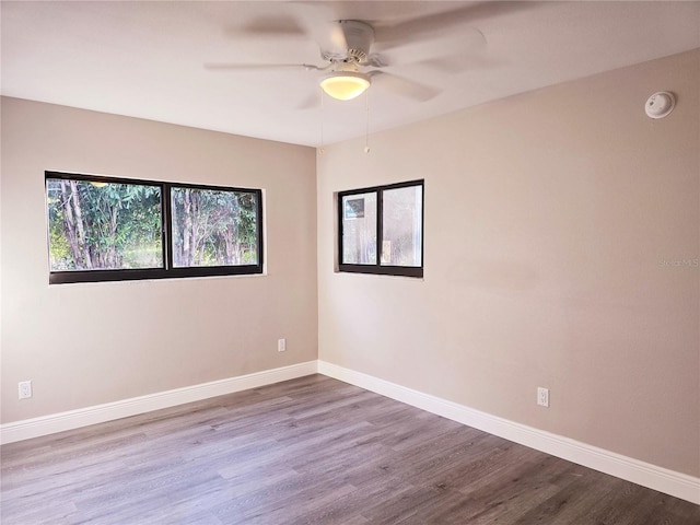 spare room featuring a ceiling fan, baseboards, and wood finished floors