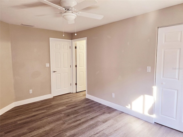 unfurnished room with ceiling fan, baseboards, and wood finished floors